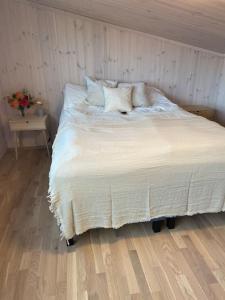 Una cama con sábanas blancas y almohadas en un dormitorio en Borestranda - Nytt strandhus med 6 sengeplasser!, en Klepp
