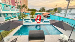a pool at a hotel with a red life preserver at Hotel Encanto Sol e Mar in Caraguatatuba
