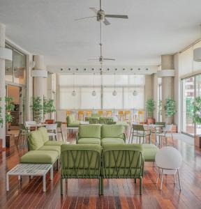 a lobby with green furniture and tables and chairs at Hotel Santamarta in Cullera