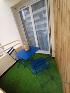a blue table and chairs in a room with a window at Le Sud, pdcompri in Toulon