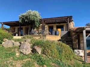une maison avec quelques rochers devant elle dans l'établissement La bergerie de Cupabia, à Serra-di-Ferro