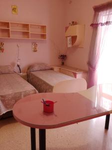 Habitación pequeña con 2 camas y mesa. en Terraced house with stunning view close to Mdina, en Rabat