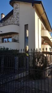 una recinzione nera di fronte a una casa bianca di ILLUVIA affitto camere a Cornaredo