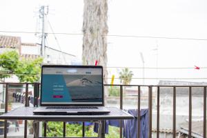 un computer portatile seduto sopra un tavolo di Cifalino - Full Cozy Apartment with Wi-Fi in Catania a Catania