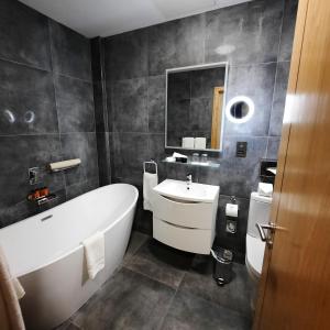 a bathroom with a white tub and a sink at Menlo Park Hotel in Galway