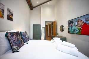 una camera con letto bianco e TV a parete di The Ruby Suite a Manchester