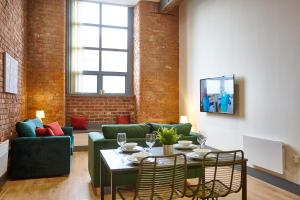 un soggiorno con un divano e un tavolo di The Ruby Suite a Manchester