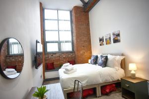 una camera da letto con un letto e uno specchio di The Ruby Suite a Manchester Altre 22 foto