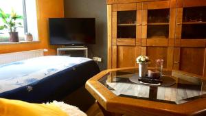 a bedroom with a bed and a coffee table with a tv at Joys Ferienwohnung in Oberhausen