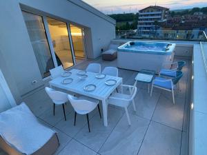 a table and chairs on a balcony with a hot tub at Haus Margarete - Attico Infinity Vista Mare con Jacuzzi - Agenzia Cocal in Caorle