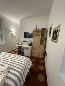 a bedroom with a bed and a desk and a television at Santa Vincenza - Suite Indipendente in Lovere