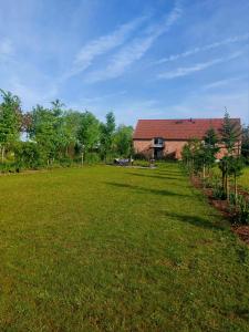 a large grass field with a building in the background at De Weldoeninge in Wingene