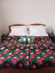 ein Bett mit einer grünen und rosa Decke mit einer Kerze darauf in der Unterkunft B&b Su Entu in Muravera