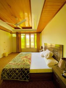 a bedroom with a large bed with a ceiling at Greenwood Resort Skardu in Skardu
