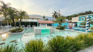 a swimming pool in a resort with turtles in the water at Hotel Encanto Sol e Mar in Caraguatatuba