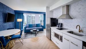 a kitchen with a sink and a table with a blue couch at Pantages Hotel Toronto Centre in Toronto