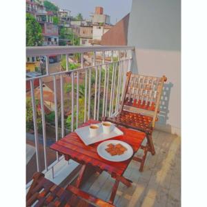 een tafel met een bord eten op een balkon bij Malini Homes Unit - 2 in Guwahati