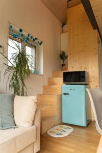a living room with a couch and a refrigerator at Tiny House Chez Claudine with Garden, Workspace, Netflix, free Parking & Wifi in Brugg