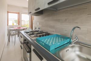 een keuken met een wastafel met een blauwe doos op het aanrecht bij Paolino Housing in Paestum