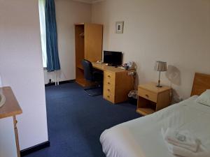 um quarto com uma secretária, um computador e uma cama em Luther King House em Manchester