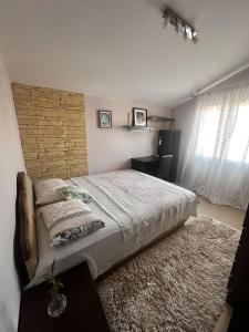 ein Schlafzimmer mit einem großen Bett und einer Ziegelwand in der Unterkunft Angella apartment Tivat in Tivat