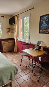 - une chambre avec une table, un lit et une fenêtre dans l'établissement Auberge la Table du Curé, à Cucugnan