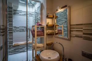 ein Bad mit einer Dusche, einem Waschbecken und einem Spiegel in der Unterkunft Old Noar Private Villa in Novara Sicilia
