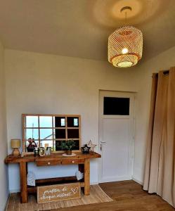 een kamer met een tafel, een raam en een kroonluchter bij Appartement charmant et spacieux in Auxerre