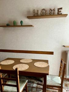 einen Esstisch mit 2 Stühlen und einem Regal in der Unterkunft Casa Margherita (Alba) in Alba
