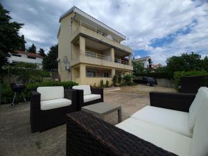 a patio with couches and chairs in front of a building at Eden apartment in Kornić