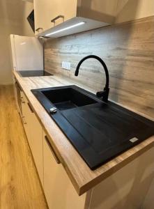 een keuken met een zwarte wastafel in een aanrecht bij Duplex 29 tout inclus in Quimper