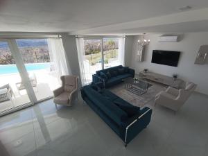 ラビンにあるVILLA NAVISのソファと椅子とテレビのあるリビングルーム
