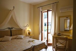 Schlafzimmer mit einem Bett, einem Spiegel und einem Fenster in der Unterkunft Hotel Gallo Nero in SantʼAndrea