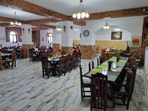 una sala da pranzo con tavoli e sedie in un ristorante di Royal Castle a Paşcani