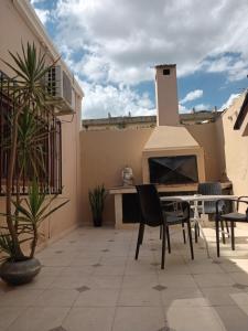 a patio with a table and chairs and a stove at Infinit Home Duplex entero in Termas de Río Hondo