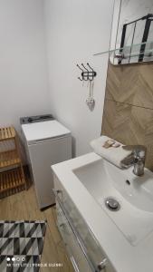 a white bathroom with a sink and a trash can at Nowy Domek z jacuzzi in Władysławowo +14 photos