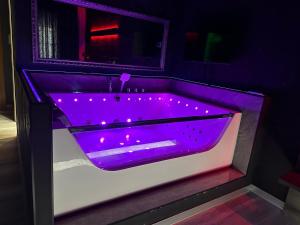 布加勒斯特Nubia studios & spa的浴室内带灯的紫色浴缸