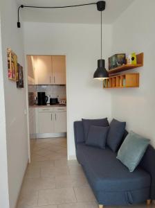 a living room with a blue couch and a kitchen at Urlaub im Herzen von Laboe in Laboe