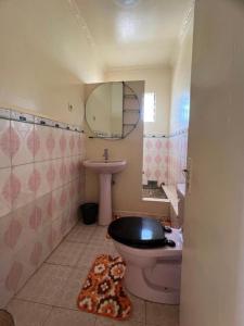 a bathroom with a toilet and a sink and a mirror at Résidence Tianay in Antananarivo