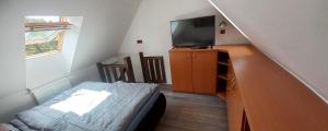 a bedroom with a bed and a tv and a staircase at H&P Apartmán Rokytno 6 in Rokytnice nad Jizerou