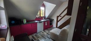 a small kitchen with red cabinets and a sink at H&P Apartmán Rokytno 6 in Rokytnice nad Jizerou