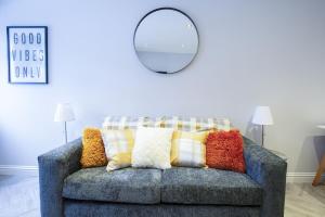 a gray couch with colorful pillows in a living room at Rothes Retreat - SJA Stays - Luxury 1 Bed House in Rothes