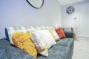 a couch with colorful pillows on it in a living room at Rothes Retreat - SJA Stays - Luxury 1 Bed House in Rothes