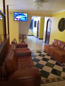 a living room with a couch and a flat screen tv at HOSPEDAJE KAROL in Ayacucho