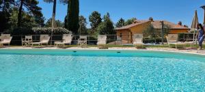 una grande piscina con sedie e una casa di Il Nido a Gambassi