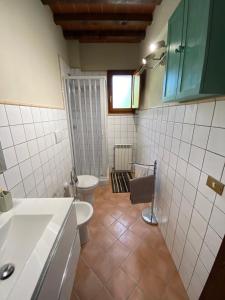 un bagno con un water bianco e un lavandino di Il Nido a Gambassi Altre 11 foto