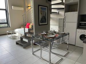 馬德里的住宿－Lujoso Loft La Moraleja，厨房配有玻璃桌和冰箱