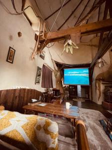 Tida House - Vacation STAY 07404v في Koshimizu: غرفة معيشة مع أريكة وتلفزيون بشاشة كبيرة