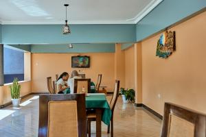 Benru Suites Hotel في كامبالا: يجلس شخصان على طاولة في مطعم