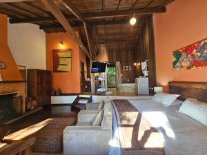 a bedroom with a bed and a couch and a tv at Estalagem Wiesbaden in Monte Verde